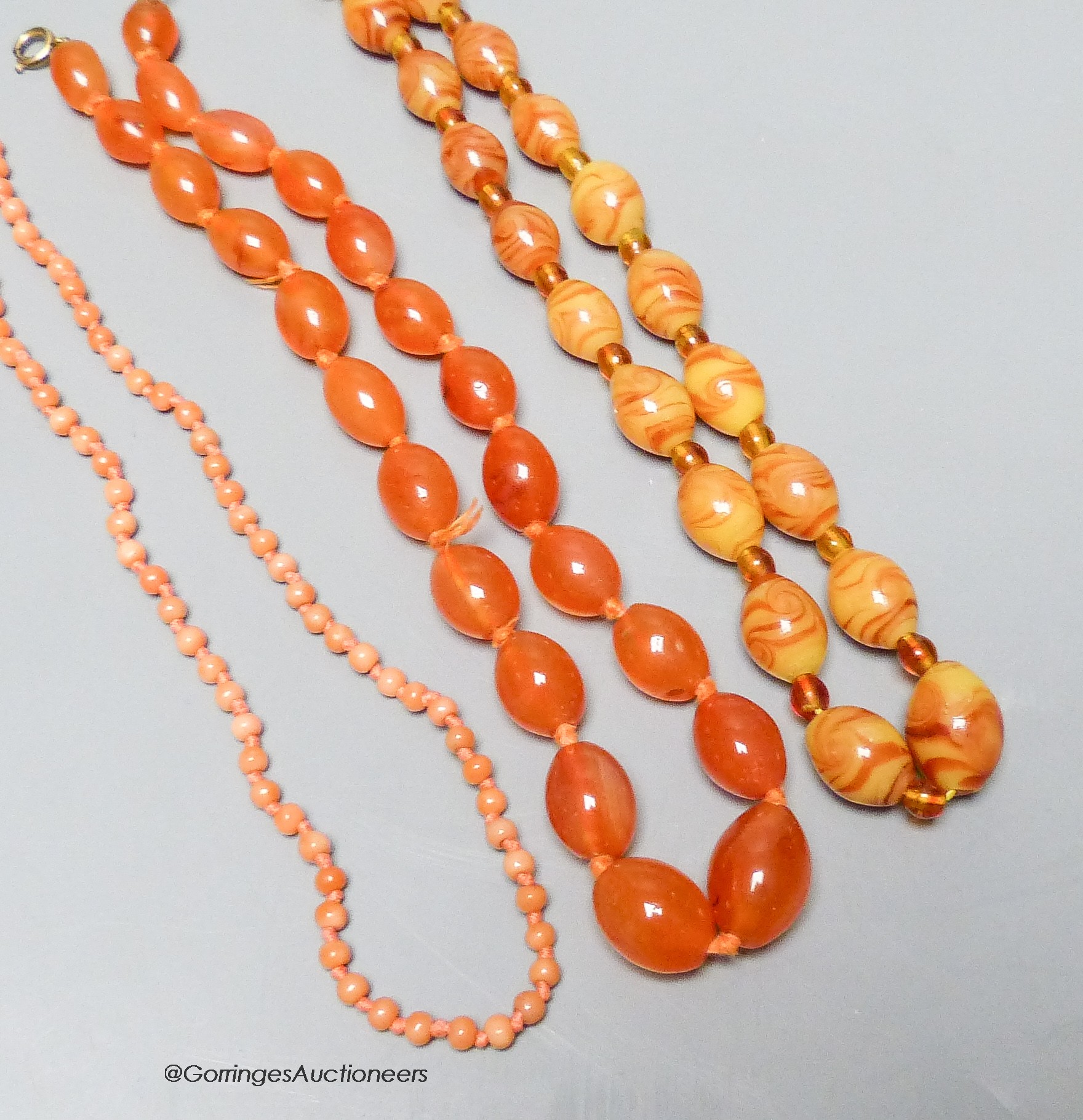 A coral bead necklace, 47cm and two other necklaces.